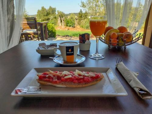 a plate with a pizza and a drink on a table at Agroturismo Can Marquet - Adults Only in Santa Gertrudis de Fruitera