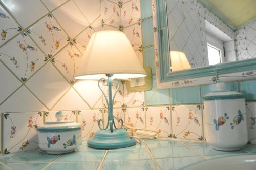 lampa na blacie w łazience obok lustra w obiekcie Villa Lanthana, 2 storeys, detached w mieście Bari Sardo