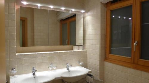 a bathroom with two sinks and a mirror at Luxury Apartment, Panoramic Mountain Views, 5* Spa Facilities - 4 Bedroom in Chateau-d'Oex