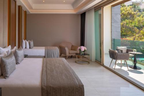 a hotel room with two beds and a balcony at Vogue Hotel Supreme Bodrum in Torba