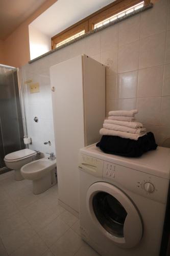 a bathroom with a washing machine with towels on it at Casa Vacanze Doralice in Barzana