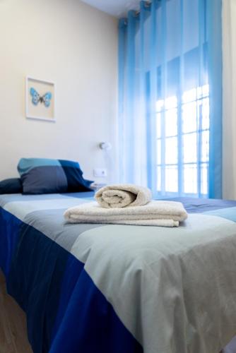 a bedroom with a bed with towels on it at FAMORCAS Centro A y B in Almodóvar del Río