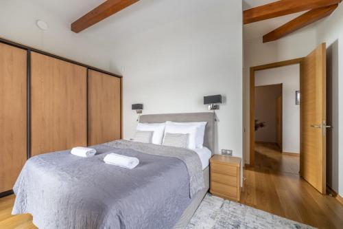 a bedroom with a large bed with two towels on it at Dabas Mājas - Your Dream Holiday Spot in Vecslavēkas