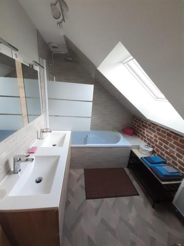 a bathroom with a sink and a bath tub at Les Gîtes du Château de Maltot in Saint-Ouen-du-Breuil