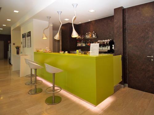 a green bar with two stools in a room at Hotel Mercure Venezia-Marghera in Marghera