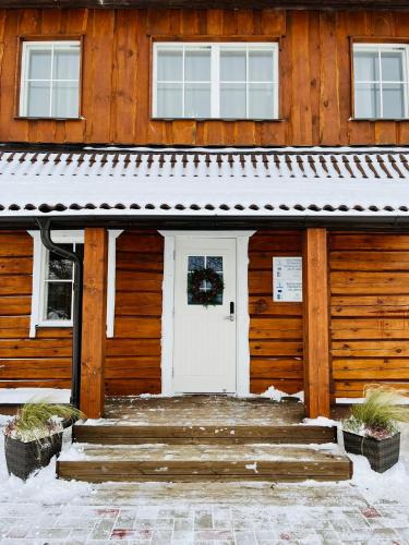 a wooden building with a white door and stairs at Rosi Puhkemaja in Koljala