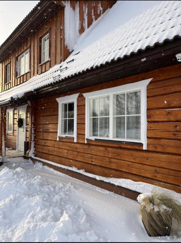 a wooden house with snow on the side of it at Rosi Puhkemaja in Koljala