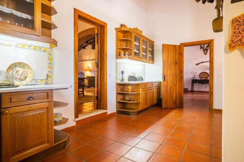 a kitchen with wooden cabinets and a tiled floor at Monte das Lages in Redondo