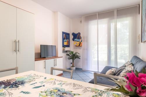 een woonkamer met een tafel en een televisie bij Bosco Canoro Bibione Resort in Bibione