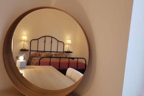 um quarto com uma cama e um espelho redondo em Appartement cosy proche la Part Dieu em Lyon