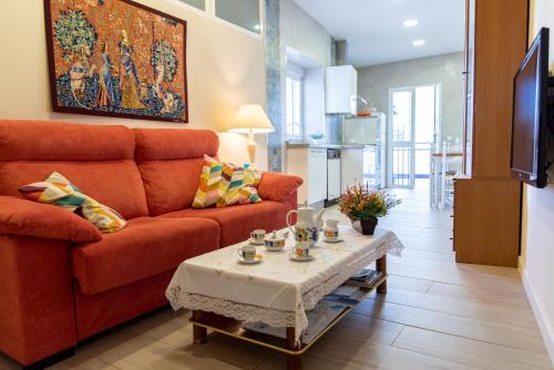 sala de estar con sofá y mesa en Aptos Centro A y B FAMORCAS, en Almodóvar del Río