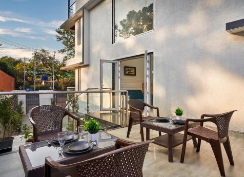 a patio with a table and chairs on a balcony at Drizzle Resort with Swimming pool Near Maapro Garden in Mahabaleshwar