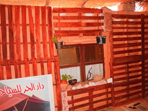 Pokój z drewnianą ścianą i oknem w obiekcie Dar Lhor w mieście Tarhjicht