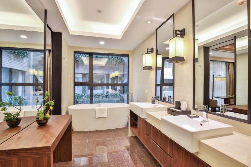 a bathroom with two sinks and a large mirror at Qianyue SSAW Boutique Hotel in Hangzhou