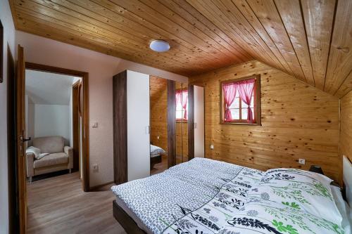 1 dormitorio con techo de madera y 1 cama en Princess's vineyard cottage, en Mirna Peč