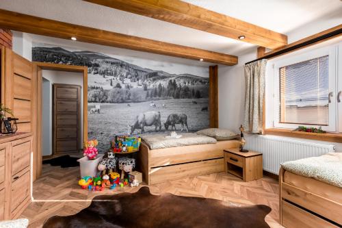 a bedroom with a mural of cows on the wall at Chata Vlčia Skala in Heľpa