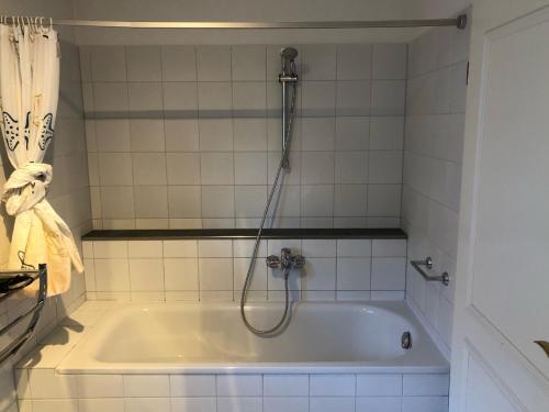 a bath tub with a shower in a bathroom at Stromstr_2 _Boddenblick_ Whg_26 in Zingst