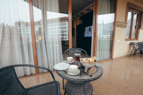 a table with two cups and a bowl of food on it at Imperial Palace Hotel Yerevan in Yerevan
