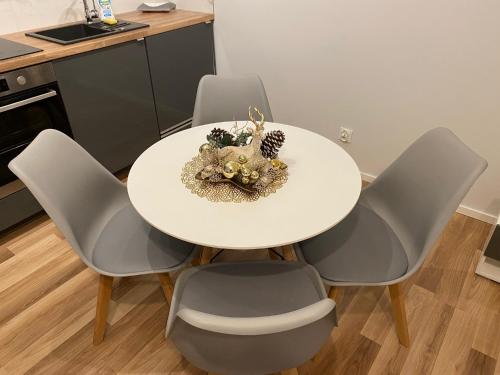 - une table et des chaises blanches avec un bol dans l'établissement Baltic Sea Apartments, à Gdańsk