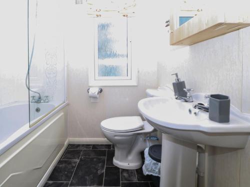 a white bathroom with a sink and a toilet at Manderine Lodge in Morpeth