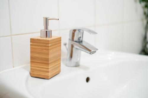 a bathroom sink with a wooden soap dispenser on it at FullHouse - Görlitz - B7 Bruno - 3 Bedrooms - SmartTV - Nespresso in Görlitz