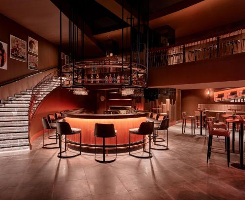 a restaurant with a bar with chairs and a staircase at Lara Barut Collection-Ultra All Inclusive in Lara