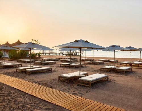 a group of tables and umbrellas on a beach at Lara Barut Collection-Ultra All Inclusive in Lara