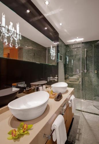 a bathroom with a large white sink and a shower at Giardino Mountain in St. Moritz