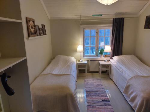 two beds in a room with a window at Brobacka Gästhem in Jomala