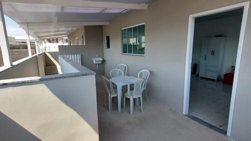 una casa con patio con mesa y sillas en Suite simple perto praia, en Cabo Frío