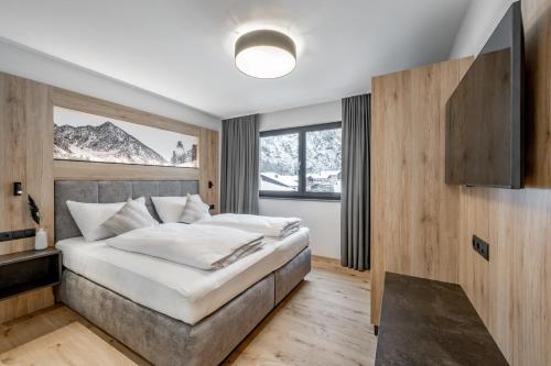 a bedroom with a large bed and a large window at Falkners Five in Oetz
