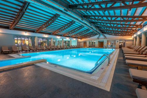 a large swimming pool with chairs in a building at Lara Barut Collection-Ultra All Inclusive in Lara