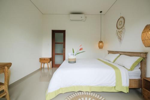 a bedroom with a large bed with white walls at The Kumpi Bali by The Lavana in Canggu