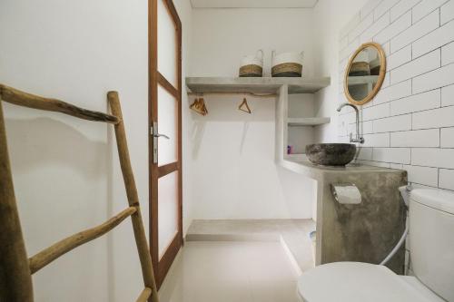 a bathroom with a toilet and a sink at The Kumpi Bali by The Lavana in Canggu