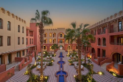 an empty courtyard with palm trees and buildings at Three Corners Ocean View El Gouna - Adults Only in Hurghada