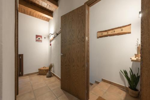 um corredor com uma porta de madeira num quarto em El Racó em Camprodon