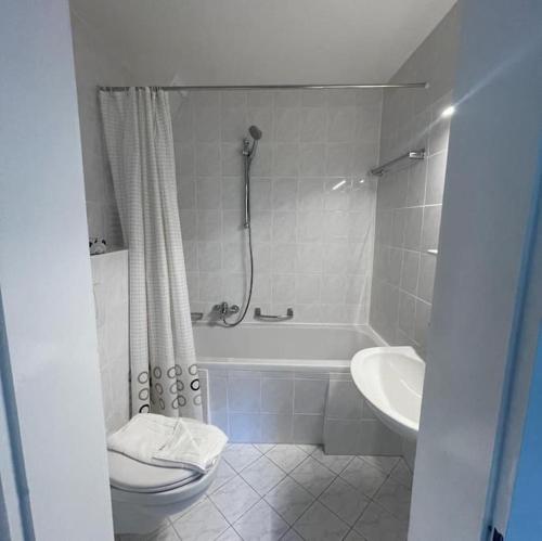 a bathroom with a tub and a toilet and a sink at Großzügige FeWo mit Bergblick am Tegernsee in Bad Wiessee