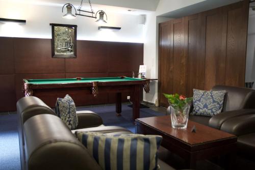 a living room with a pool table and couches at Hotel Patria Zakopane Centrum in Zakopane