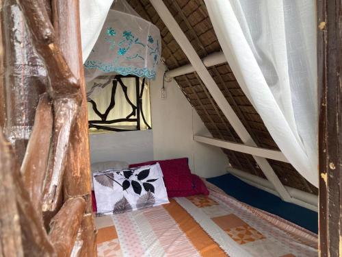 a small room with a bed and a window at CASA DEL PUEBLO DE CABANACAN in Bulacan
