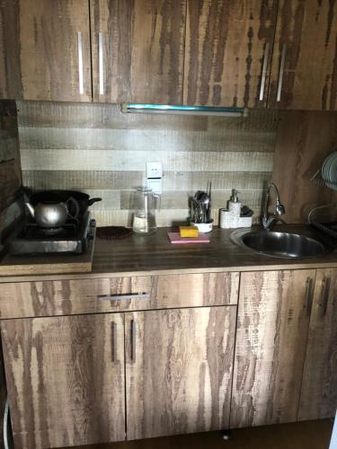 a kitchen with wooden cabinets and a sink and a counter at Деревенский домик,Eco Chakvi in Chakvi