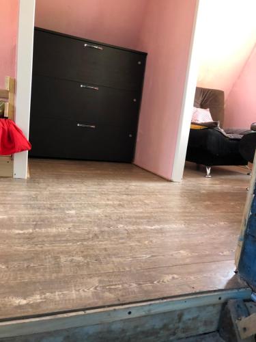a room with a wooden floor and a black dresser at Деревенский домик,Eco Chakvi in Chakvi