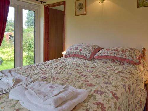 a bedroom with a bed with towels on it at Mickrandella in Martham