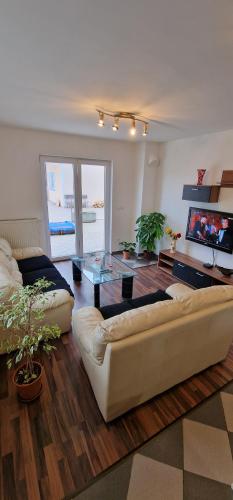 sala de estar con sofá blanco y mesa de cristal en APARTMAN MURKO S-1, 