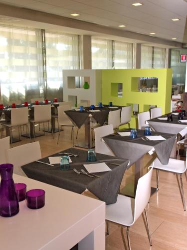 a dining room with tables and chairs with purpleitures at Hotel Mercure Venezia-Marghera in Marghera