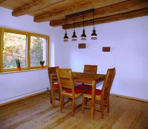 uma sala de jantar com uma mesa de madeira e cadeiras em Ferienhaus In der Erlebach em Elmstein