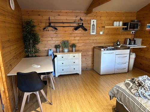 een keuken met een tafel en een wastafel in een kamer bij Southernwood - Garden Lodge 3 in Didcot