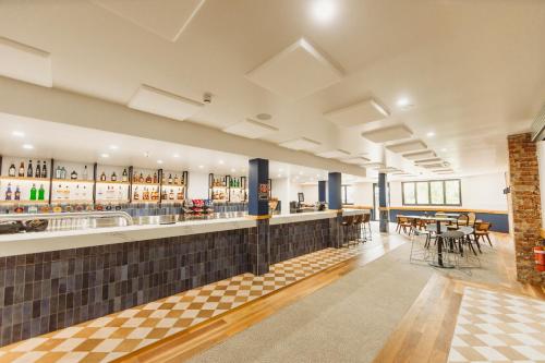 a bar in a restaurant with tables and chairs at The Albion Hotel in Cootamundra