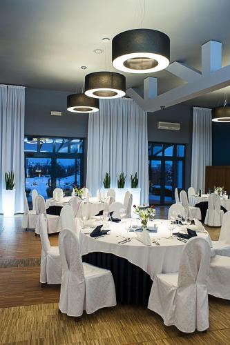 a dining room with white tables and white chairs at Hotel Eden in Rzgów