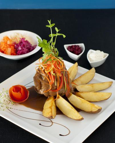 a plate of food with french fries and a sandwich at Hotel Eden in Rzgów