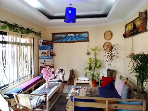 een woonkamer met meubilair en een blauw plafond bij Swahili House & Art in Arusha